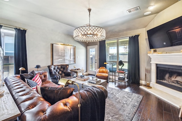 living room with dark hardwood / wood-style floors, vaulted ceiling, and a notable chandelier