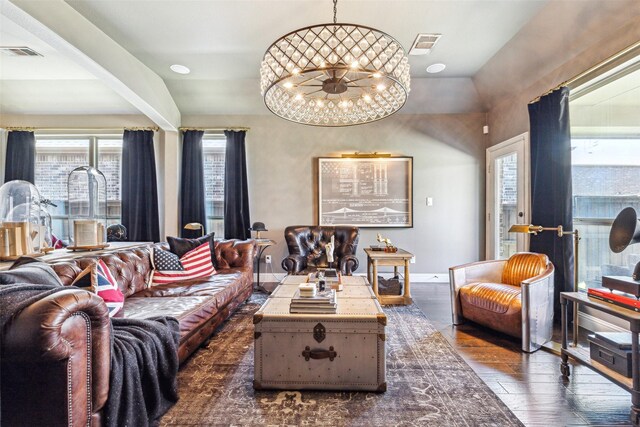 living room featuring dark hardwood / wood-style flooring, vaulted ceiling, and a notable chandelier