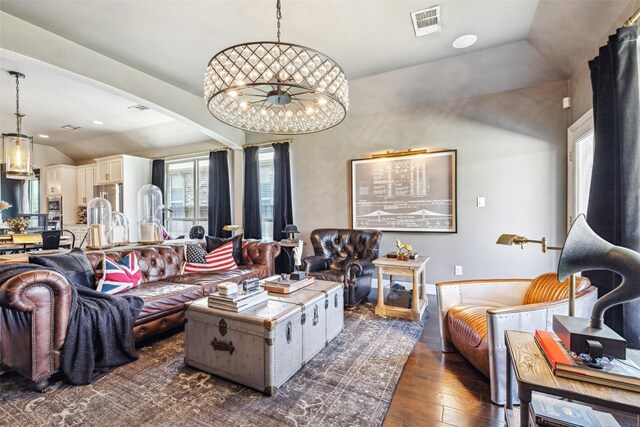 living room featuring dark hardwood / wood-style flooring, an inviting chandelier, plenty of natural light, and lofted ceiling