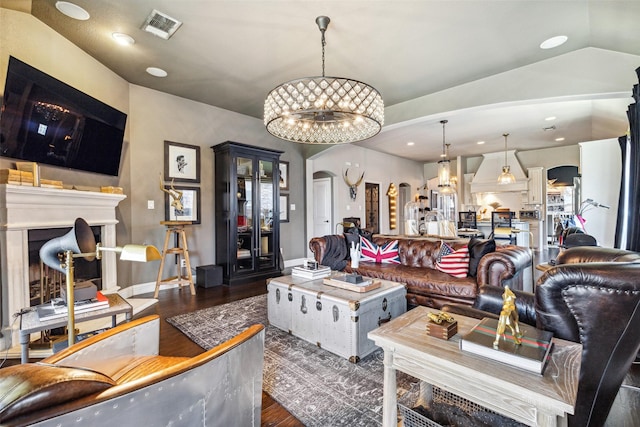 living room with dark hardwood / wood-style flooring, lofted ceiling, and a chandelier