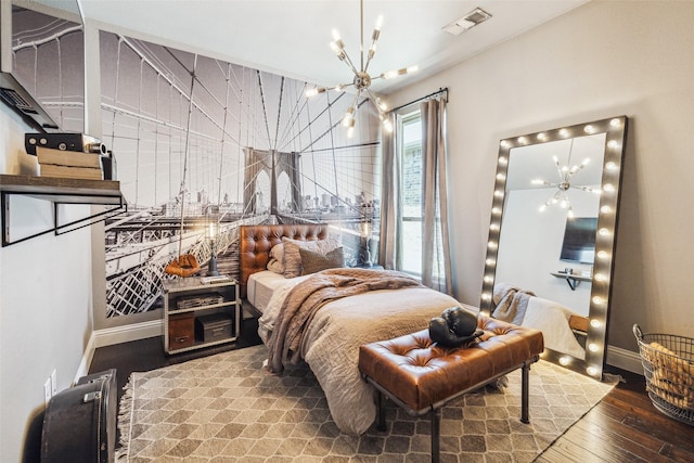 bedroom featuring wood-type flooring and an inviting chandelier