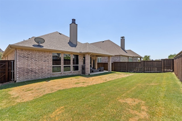 rear view of property with a lawn and a patio area