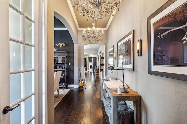 corridor featuring dark hardwood / wood-style flooring, a high ceiling, and an inviting chandelier