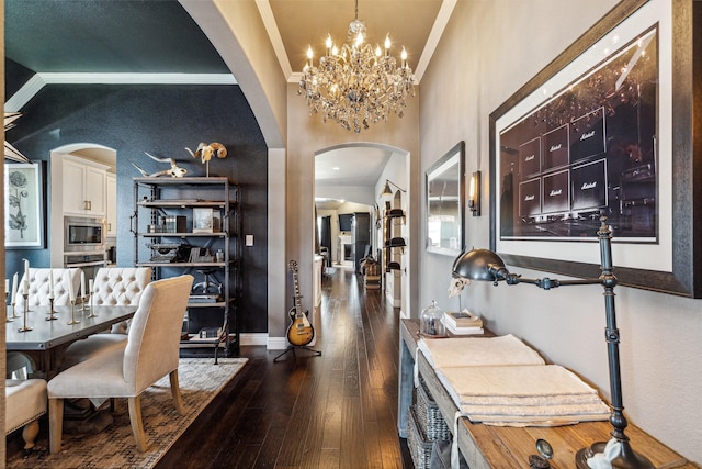 dining room with dark hardwood / wood-style floors, an inviting chandelier, and crown molding