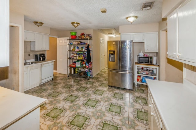 kitchen featuring dishwasher, stainless steel fridge, white cabinetry, and a textured ceiling