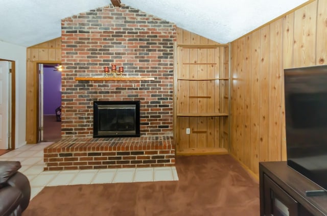 living room with lofted ceiling, a textured ceiling, wooden walls, and a brick fireplace