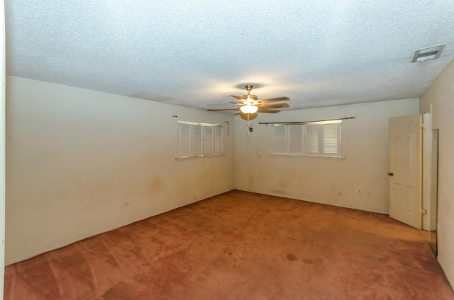 spare room with carpet, ceiling fan, and a textured ceiling