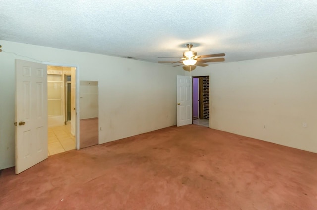 spare room featuring a textured ceiling, light colored carpet, and ceiling fan