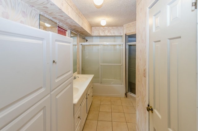 bathroom with tile patterned floors, vanity, shower / bath combination with glass door, and a textured ceiling