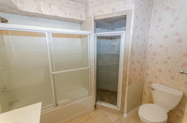 bathroom with tile patterned floors, combined bath / shower with glass door, and toilet