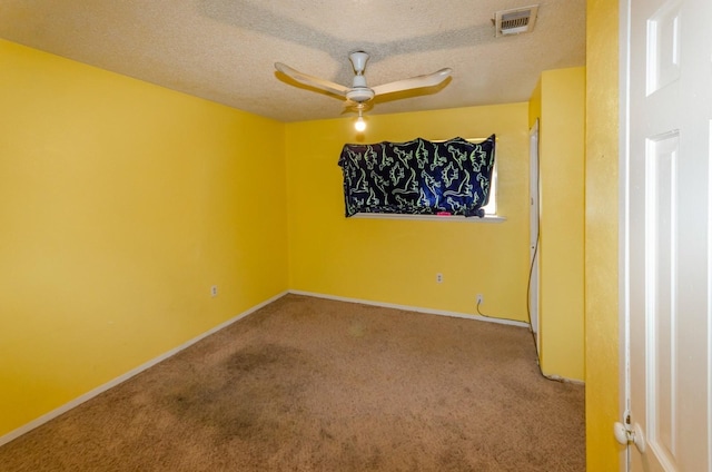 carpeted spare room with ceiling fan and a textured ceiling