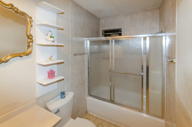 bathroom with toilet and shower / bath combination with glass door