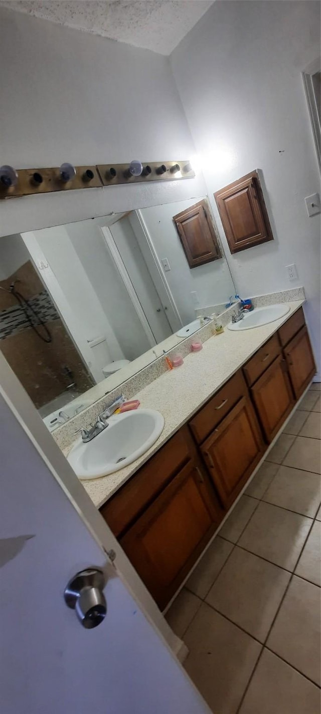 bathroom featuring tile patterned floors, a sink, and double vanity