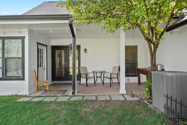 exterior space featuring a porch, cooling unit, and a lawn