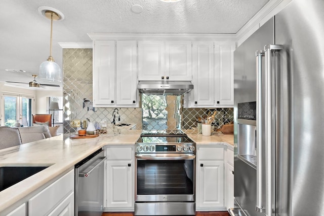 kitchen featuring decorative light fixtures, white cabinetry, and stainless steel appliances