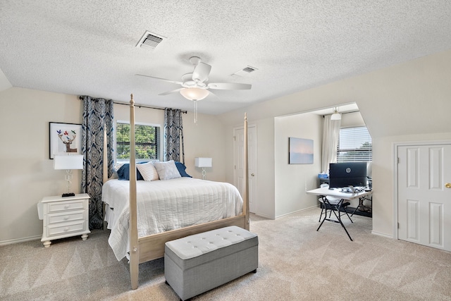 bedroom featuring light carpet, a textured ceiling, and ceiling fan