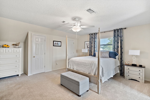 carpeted bedroom featuring ceiling fan, a textured ceiling, and a closet