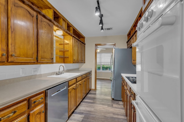 kitchen featuring ceiling fan, sink, stainless steel appliances, light hardwood / wood-style flooring, and track lighting