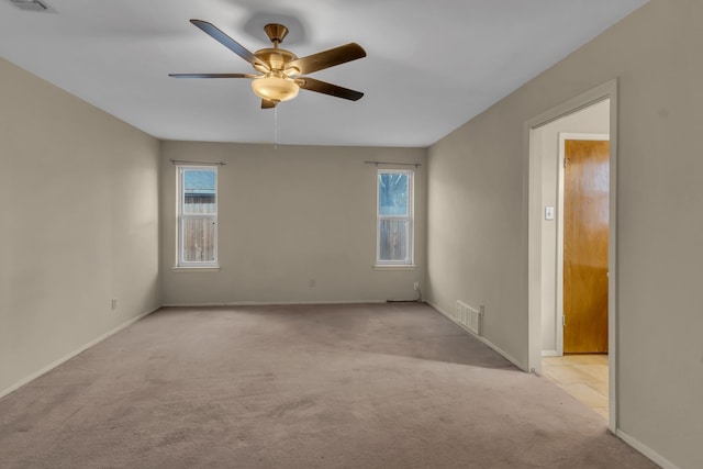 spare room featuring ceiling fan and light carpet