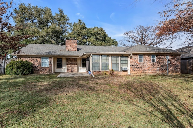 rear view of property with a patio and a lawn