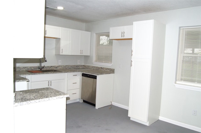 kitchen with sink, white cabinets, stainless steel dishwasher, and concrete floors