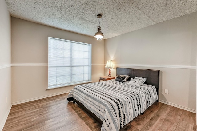 bedroom with wood-type flooring and multiple windows