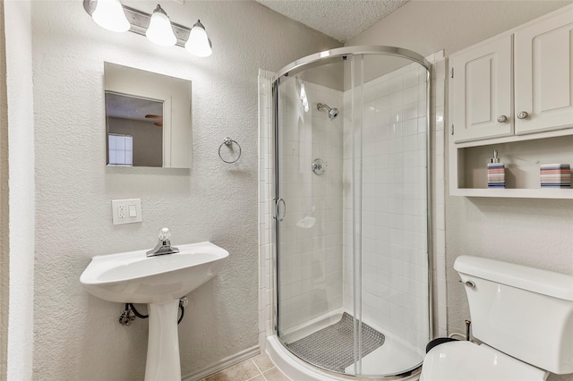 bathroom featuring tile patterned flooring, toilet, a textured ceiling, and an enclosed shower