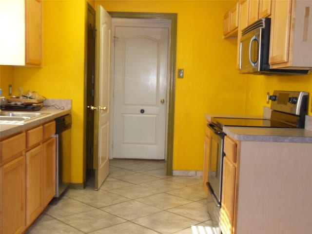 kitchen with light tile patterned floors, stainless steel appliances, and sink