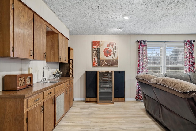 kitchen with dark countertops, light wood-style floors, brown cabinets, and a sink