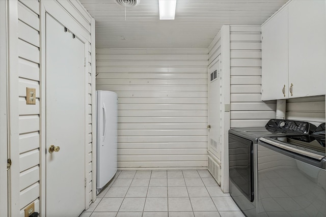 kitchen with light tile patterned floors, wooden ceiling, washing machine and dryer, white cabinets, and freestanding refrigerator