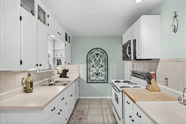 kitchen with light tile patterned floors, white range with electric stovetop, white cabinets, stainless steel microwave, and a sink