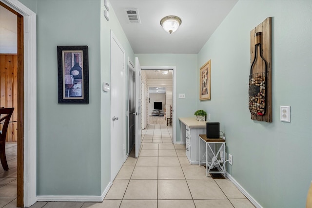 hall with visible vents, baseboards, and light tile patterned floors