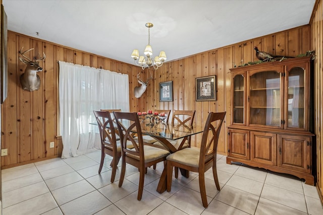 dining area with wooden walls, a notable chandelier, and light tile patterned flooring