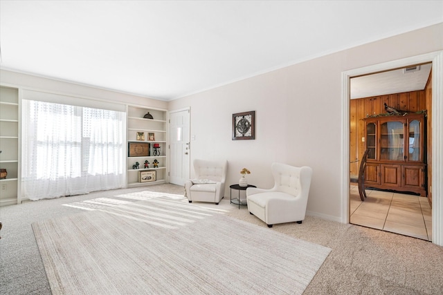 unfurnished room with carpet flooring, visible vents, and wooden walls