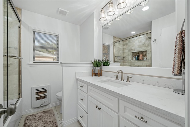 bathroom with tile patterned floors, heating unit, visible vents, toilet, and vanity