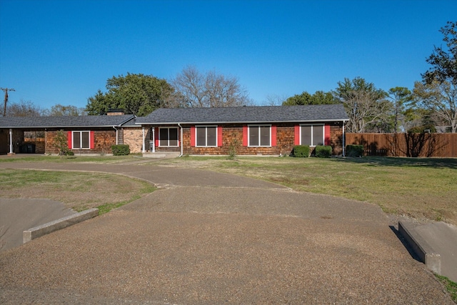 single story home featuring aphalt driveway, a front lawn, fence, and brick siding