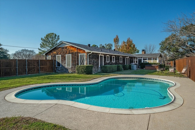 view of swimming pool with a fenced in pool, a fenced backyard, central AC, a hot tub, and a yard