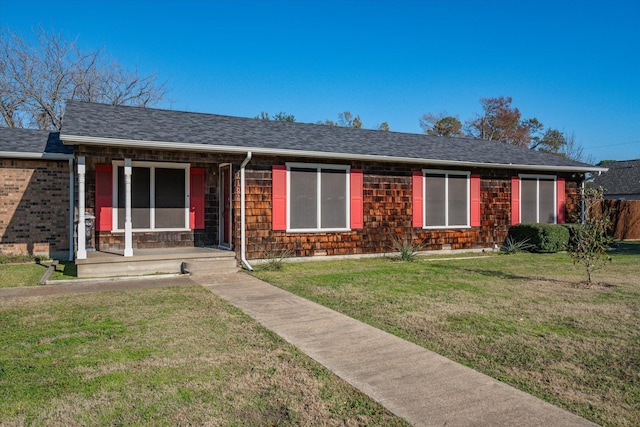 single story home featuring roof with shingles and a front yard