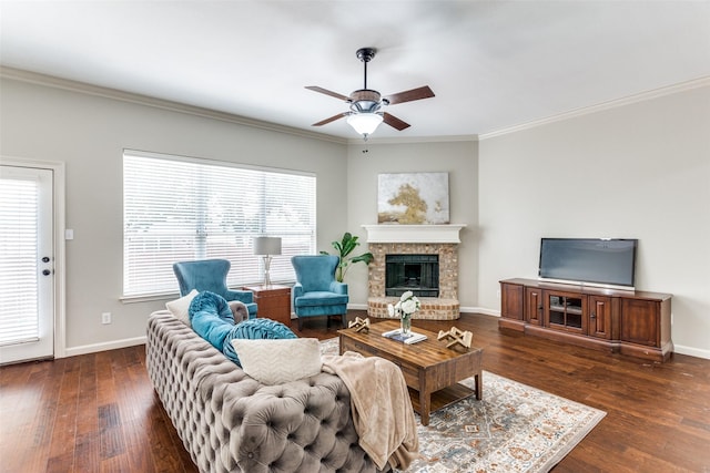 living room with crown molding, a wealth of natural light, and a brick fireplace