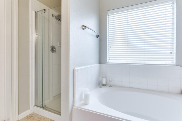 bathroom featuring shower with separate bathtub