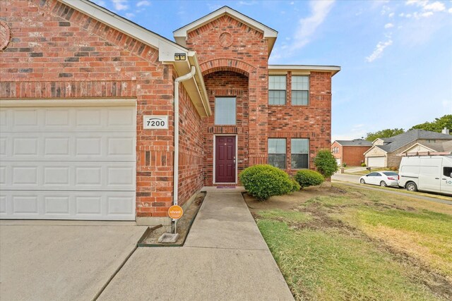 view of property featuring a front yard and a garage