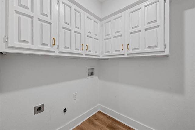 washroom featuring gas dryer hookup, electric dryer hookup, cabinets, washer hookup, and wood-type flooring