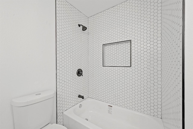 bathroom with tiled shower / bath combo and toilet