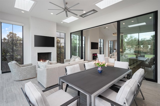 dining area featuring a large fireplace and ceiling fan