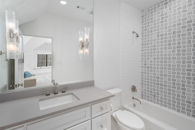 full bathroom with lofted ceiling, vanity, tiled shower / bath combo, and toilet