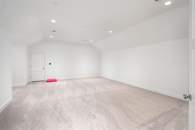 additional living space with light colored carpet and lofted ceiling