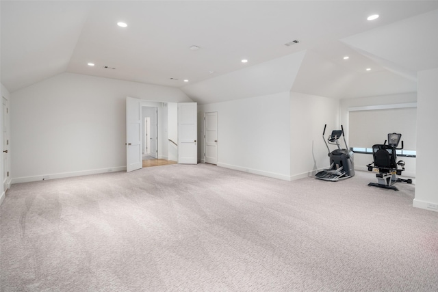 exercise area featuring light colored carpet and lofted ceiling