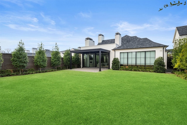 back of house with a lawn, a sunroom, and a patio