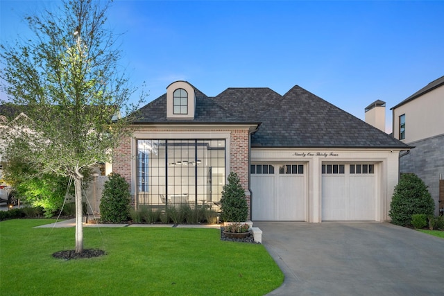 french country style house featuring a front yard and a garage