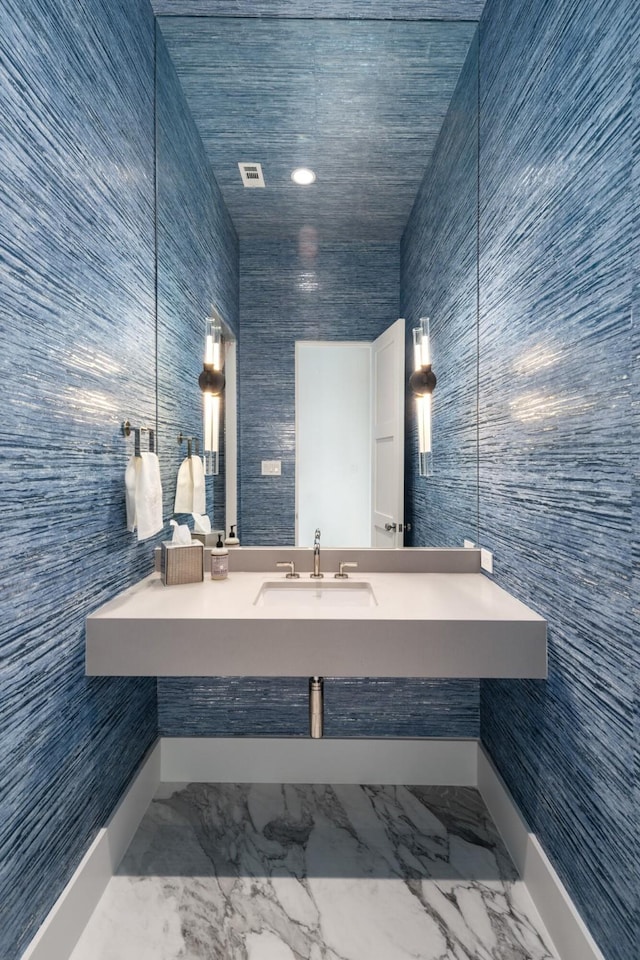 bathroom with vanity and tile walls